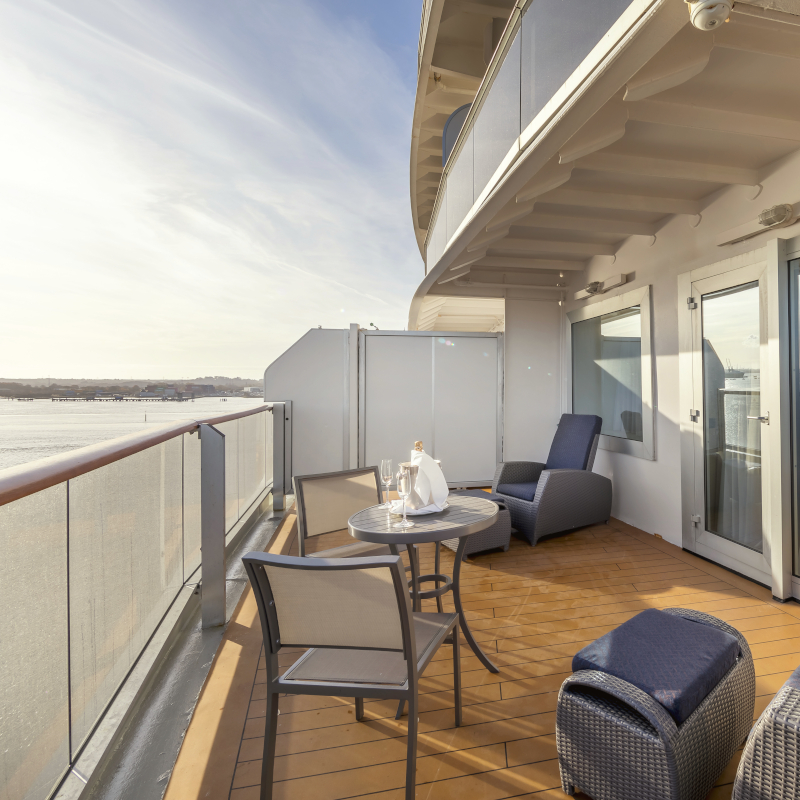 Private cruise balcony with a champagne table setup overlooking the water.