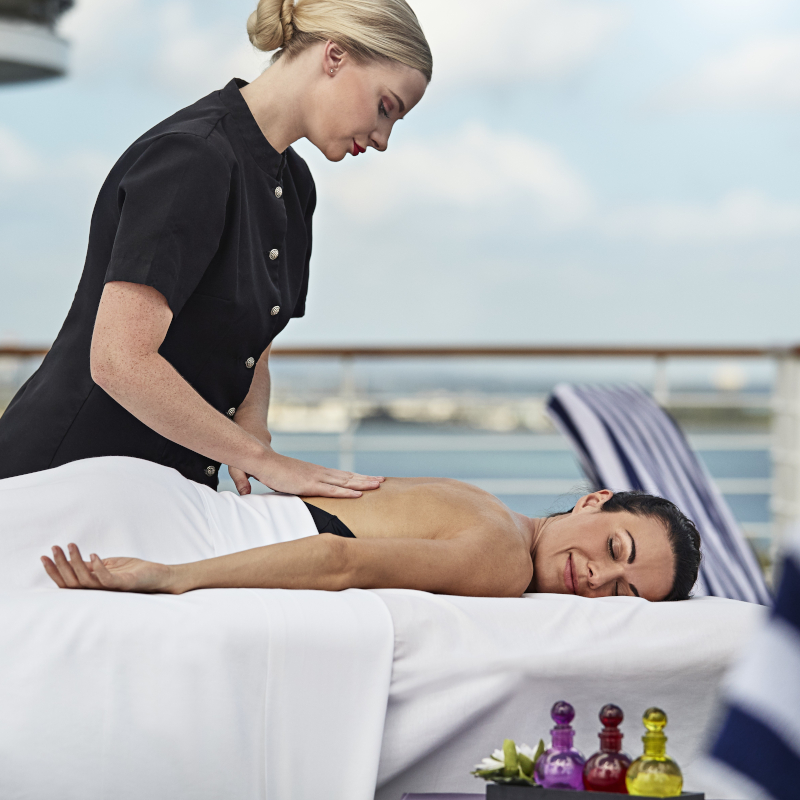 Woman receiving an outdoor relaxing back massage on the cruise ship deck.